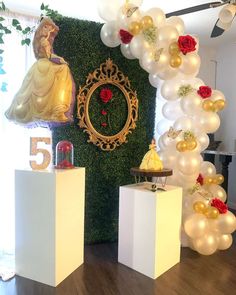 balloons and decorations on pedestals in front of a wall with an image of a princess