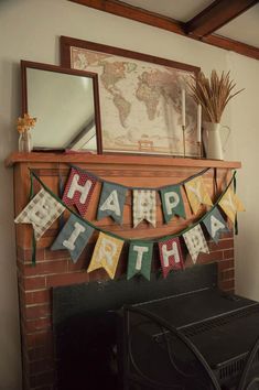 a happy birthday banner hanging from the mantle above a fire place in a living room