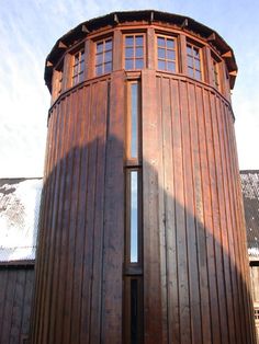 a tall wooden building sitting next to a parking lot