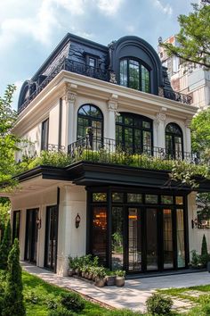 a black and white house with lots of windows on the top floor, balconies above it