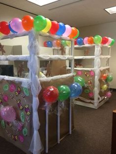 balloons and streamers are on display in an office cubicle for children's birthdays