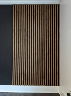 an empty room with black walls and wooden slats