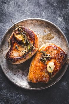 two pieces of meat sitting on top of a plate