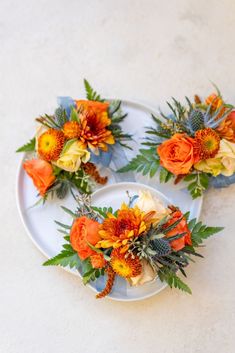 three white plates with orange and yellow flowers on them