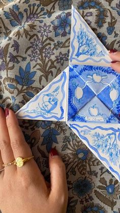 a woman's hand is holding an origami piece