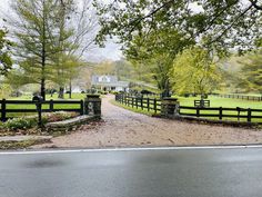 a gated driveway leading to a farm house