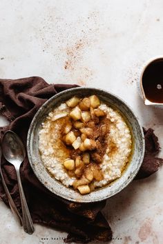 a bowl filled with oatmeal and nuts next to a cup of coffee