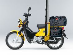 a yellow scooter with a black bag on the back