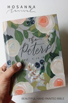 a hand holding up a book with flowers on it and the title, the peters