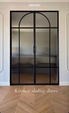 an open glass door with the words kitchen sliding doors on it in front of a wooden floor