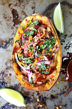 an overhead view of a taco dish with onions, cilantro and lime wedges