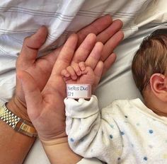 a baby is being held in the palm of someone's hand with a name tag on it