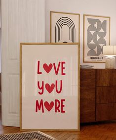 two framed art pieces sitting on top of a hard wood floor next to a dresser