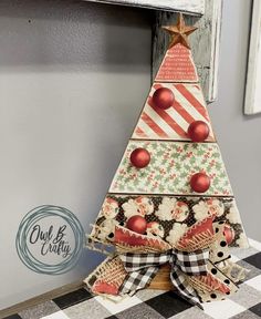 a wooden christmas tree with ornaments on it