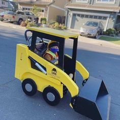 a small yellow construction vehicle on the street