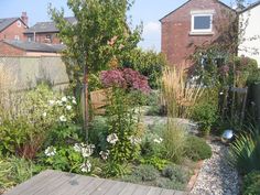 a wooden deck in the middle of a garden