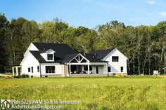 a large white house sitting in the middle of a lush green field with lots of trees