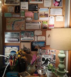 a cluttered desk with lots of papers on the wall and pictures all over it