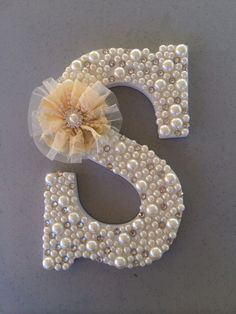 the letter s is decorated with pearls and a flower