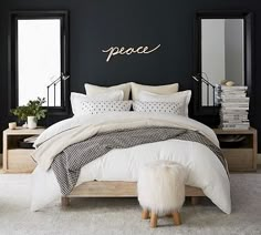 a bedroom with black walls and white bedding