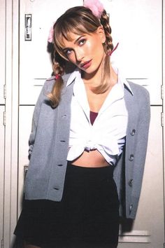 a woman in a white shirt and black skirt standing next to lockers