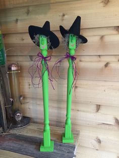 two green candles with witches hats on them