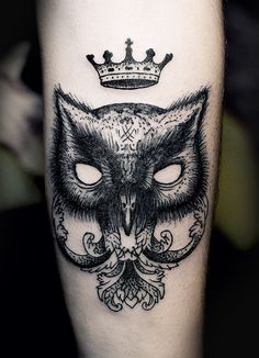 an owl with a crown on top of it's head is depicted in this tattoo