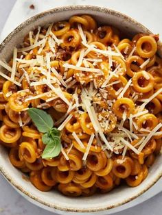 a bowl filled with pasta and topped with parmesan cheese