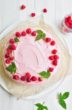 a cake with raspberries and mint leaves on it