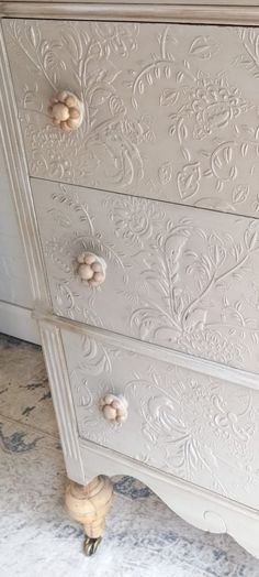 an ornate white dresser with gold handles and knobs on the drawers is shown in this image