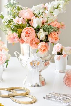 a vase filled with pink and white flowers on top of a table next to scissors