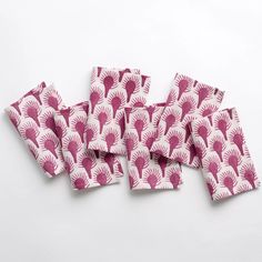 six napkins with pink and white designs on them