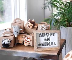 there are stuffed animals on the table next to a sign that says adopt an animal