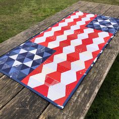 a red, white and blue quilt on a picnic table