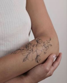 a woman with a flower tattoo on her arm