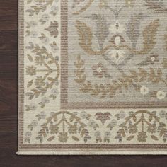 a beige and brown rug on top of a wooden floor