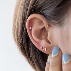 a close up of a person's ear with two piercings on top of it