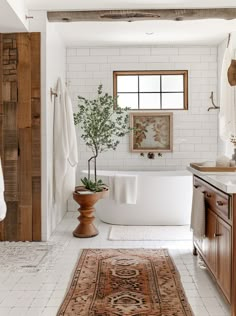 a bathroom with a rug, sink and bathtub in it's center area