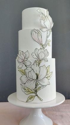 a three tiered white cake with flowers on it