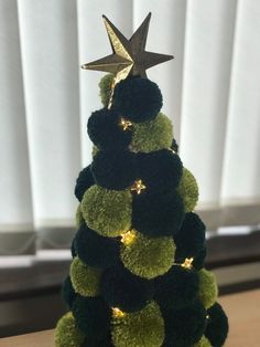 a small christmas tree made out of pom - poms with a star on top