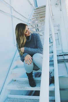 a woman sitting on top of a set of stairs