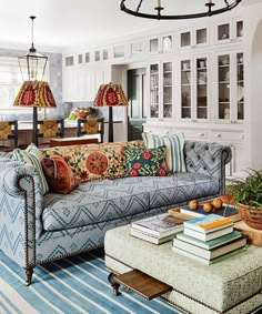 a living room filled with furniture and lots of books on top of a coffee table