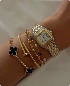 a woman's arm with bracelets and watches on it