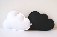 two black and white clouds sitting next to each other on top of a table in front of a wall