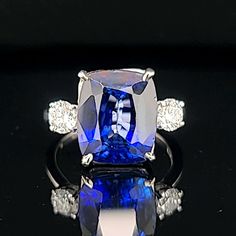 This vintage platinum three-stone ring features a stunning cushion-shaped lab-grown blue sapphire as its center stone, with two lab-grown diamonds on either side. The ring is perfect for special occasions like engagements, weddings, anniversaries, birthdays, Valentine's Day, Christmas, Mother's Day, or graduation, with adjustable sizing to fit a size 7.5 finger. GORGEOUS vintage platinum  engagement three stones ring gem lab-grown blue sapphire in a cushion shape,  Center set gorgeous blue sapph Luxury Cushion Cut Sapphire Ring With Vvs Clarity, Sapphire Platinum Diamond Ring Cushion Cut, Sapphire Cushion Cut Diamond Ring In Platinum, Platinum Sapphire Cushion Cut Diamond Ring, Formal Sapphire Ring With Cushion Diamond Cut, Formal Sapphire Ring With Cushion Cut, Classic Sapphire Ring With Vvs Clarity Cushion Cut, Elegant Sapphire Ring With Vvs Clarity Cushion Cut, Timeless Sapphire Cushion Cut Ring