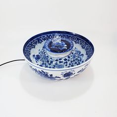 a blue and white bowl sitting on top of a table next to a charger