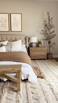 a bedroom with a bed, nightstands and two pictures on the wall above it