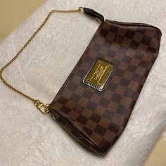 Like New , Worn A Handful Of Times. No Scuffs Or Peeling . Damier Ebene Canvas. Red Interior Canvas . Dark Brown Leather And Gold-Tone Hardware. Features A Removable Shoulder Strap, And A Chain Link Shoulder Strap To Carry The Bag As A Clutch. Comes With Dust Cover, Leather Strap, And Gold Chain . Chic Brown Clutch With Chain Strap, Designer Brown Wallet On Chain With Chain Strap, Brown Wallet On Chain With Removable Pouch, Brown Clutch With Chain Strap, Louis Vuitton Eva Clutch, Louis Vuitton Eva, Leopard Print Shoulder Bag With Detachable Strap For On-the-go, Red Interior, Damier Ebene