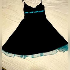 Make A Statement At Your Next Event With This Stunning Black And Aqua Dress From Intrigue. The Knee-Length Dress Features A V-Neckline And Spaghetti Straps, Perfect For Showing Off Your Shoulders And Neck. The Dress Is Made Of Lightweight Polyester With A Satin And Tulle Fabric Type, And Comes With Pleated Accents, A Tulle Hem And A Bow Detail, Adding A Touch Of Femininity To The Dress. It's Perfect For Any Occasion Such As Travel, Wedding, Party, Cocktail Or Formal Events. This Dress Is Availab Black Lined Dresses For Prom, Black Lined Dress For Prom, Lined Black Dress For Prom, Coquette Prom, Black Lace Midi Dress, Red Shirt Dress, Dress Bow, Aqua Dress, Ivory Dresses