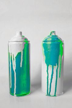 two green and white canisters sitting next to each other on a white surface